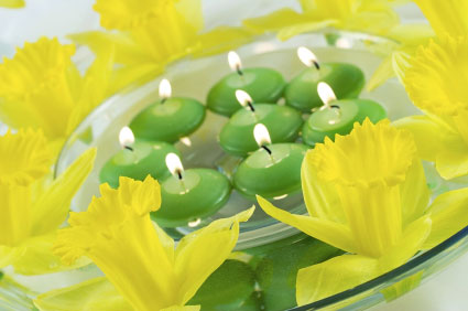 Put several floating candles in each bowl, along with a few flower blossoms