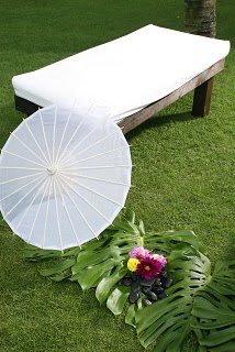 soothing white color seating like a bed and umbrella for theme wedding