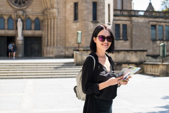 Travel guide, tourism in Europe, woman tourist with map on the street