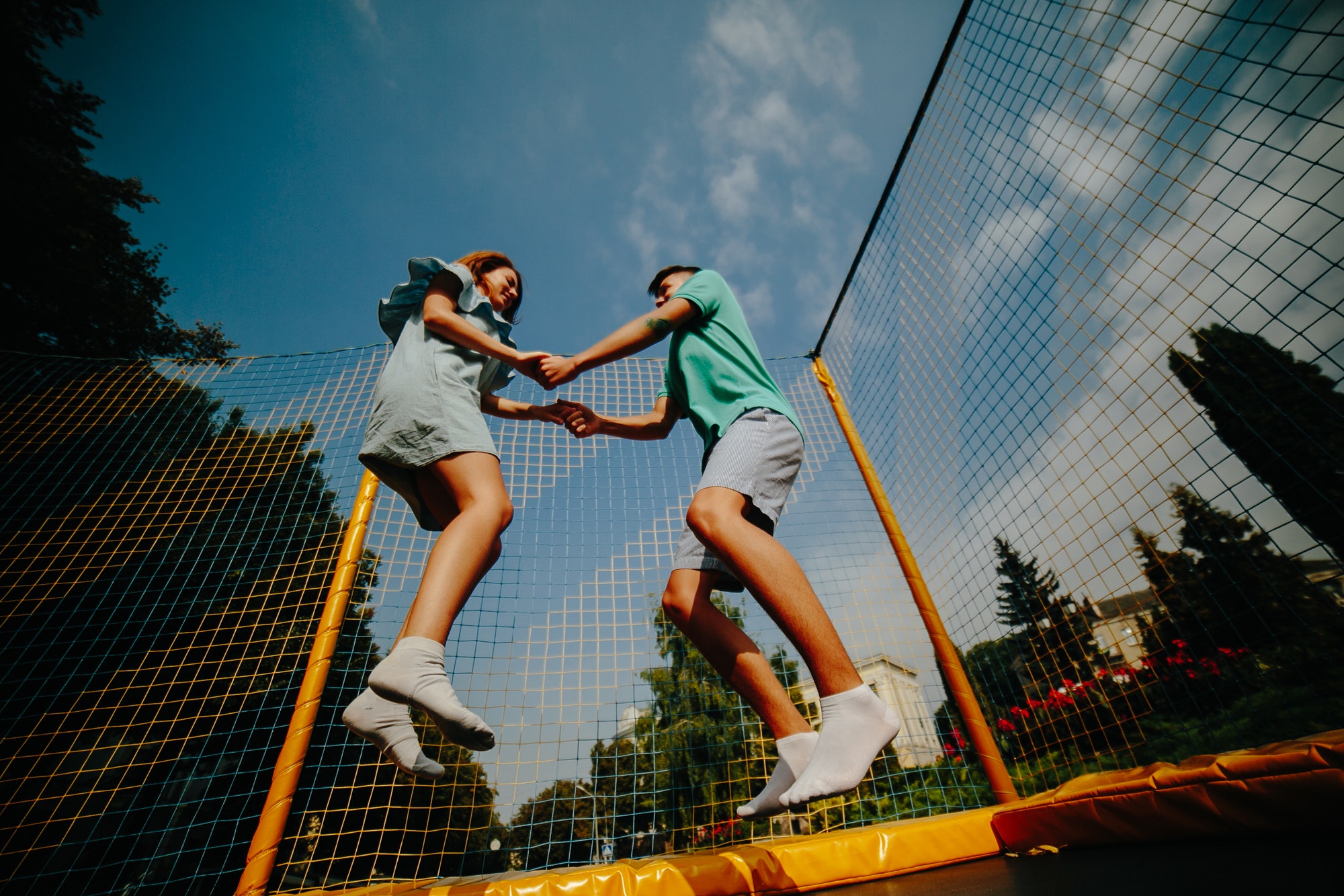 Couple jumping on trampoline in the park